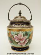 A pedestal biscuit barrel hand decorated with lilies and with plated mounts, lid and swing handle,