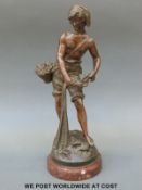A spelter figure of a young fisherman casting his net on a marble base,