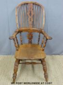 A 19thC elm seated Windsor armchair with shaped yew armrests and frame and spindle supports raised