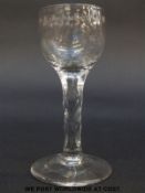 A Georgian mead glass with engraved decoration to the rim of the bowl over multi-faceted stem