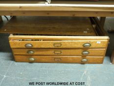 An oak three drawer plan chest containing a large quantity of hardware fittings and accessories