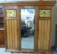 A 19th/20thC oak Aesthetic/Arts and Crafts influenced three drawer wardrobe with inlaid,