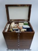 A vintage mahogany travelling dentist's cabinet and contents with lift up lid and six drawers below