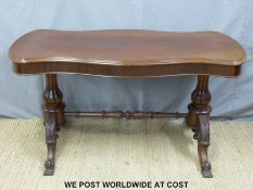 A 19thC mahogany serpentine shaped library table with turned and moulded supports united by a