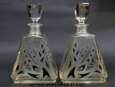 A pair of Art Deco glass decanters of triangular form with black flash overlaid and engraved