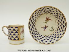 An unusual cup and saucer with bird decoration and blue and gilt geometric design,