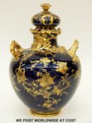Royal Crown Derby twin handled lidded pedestal vase with gilded decoration on a navy blue ground