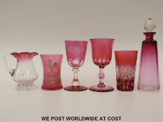 Six pieces of cranberry glassware comprising three flash overlaid cut glasses, Mary Gregory jug,