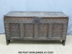 A large 17th/18thC carved elm four panel coffer with candle box raised raised on simple V shaped