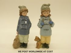 Two Nao figures of children wearing winter coats
