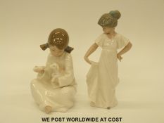 Two Nao figures, one a girl holding a lamb,