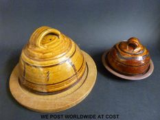 A Winchcombe Pottery style cheese dome with oak board and another smaller example