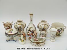 A collection of continental ceramics to include a pair of hand decorated flower encrusted pedestal