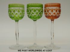 A set of three flash overlaid cut glass wine glasses with faceted stems on star cut bases,