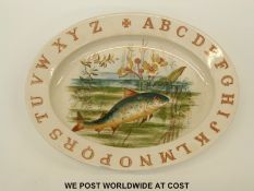 An early 20thC earthenware baby's plate with alphabet decoration