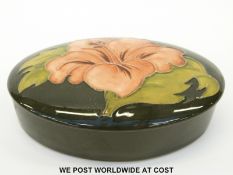 Moorcroft oval lidded dish in Hibiscus pattern on a green ground