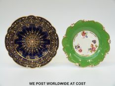 A plate with dark blue ground and gilt jewelled decoration and another with hand painted flowers to