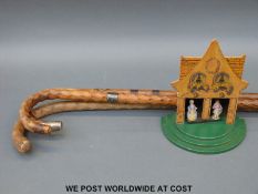 Three walking canes, one with hallmarked silver collar together with a weather house,