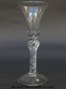 A Georgian wine glass with elongated trumpet bowl over waisted inverted baluster air twist stem