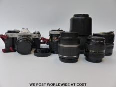 Canon AE-1 program camera together with four further lenses EF-S 18-55mm: Canon FD 135mm;