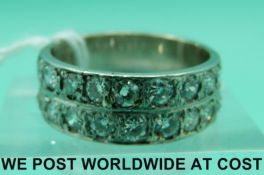 A white metal ring marked 18ct set with two rows of round cut diamonds, measuring approximately 0.