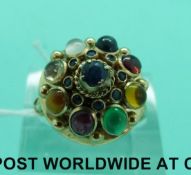 A yellow metal ring set with sapphires, emerald, garnet, ruby, moonstone,