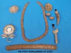 A collection of white metal filigree jewellery, horn jambia brooch, carved keris handle etc.