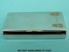 A continental white metal snuff box with gold initials to front,