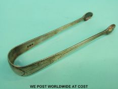 A pair of Georgian silver hallmarked sugar tongs with bright cut decoration,