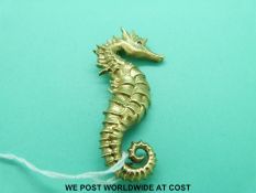 A yellow metal brooch marked 18k in the form of a sea horse with ruby eyes (25.