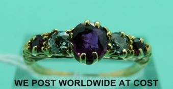 A yellow metal ring set with three rubies and two diamonds (size O)