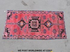 A small Turkoman style rug on red ground (276 x 133cm)