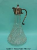 A cut glass decanter with plated mask spout mount,