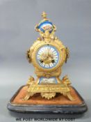 A 19th century French Ormulu two train clock with masked details and Sevres panel decoration,