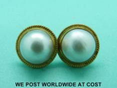 A pair of 18ct gold earrings set with a mabe pearl to each
