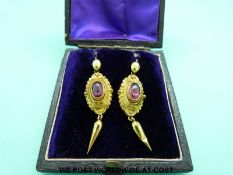 A pair of Victorian yellow metal earrings set with garnet cabochons
