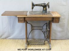 A Singer oak treadle sewing machine (width 86cm)