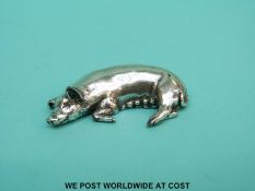 A cast hallmarked silver model of a pig lying down, London 2000 with millennium mark,