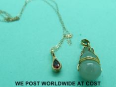 A jadeite pendant in yellow metal mount and a 9ct gold pendant set with a garnet