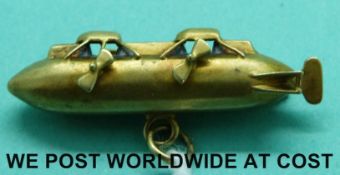 A yellow metal charm formed as an airship