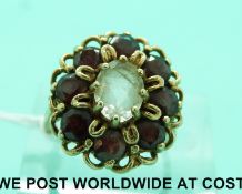A 9ct gold ring set with an oval quartz surrounded with garnets (size J)