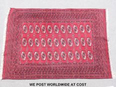 A Turkoman rug with three rows of eleven guls on a wine ground 187x128cm