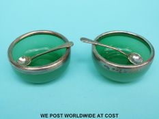 A pair of hallmarked silver mounted green glass salts,