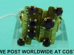 A yellow metal ring set with rubies in a rectangular textured setting (size Q)