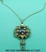 An Edwardian 9ct gold pendant set with purple guilloche enamel and seed pearls on a 9ct gold chain