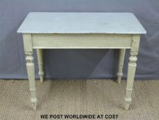 A painted and distressed table raised on turned legs (H72cm x W92cm x D50cm)