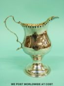 A Georgian hallmarked silver pedestal cream jug, London 1774 maker's mark rubbed but possibly PS,