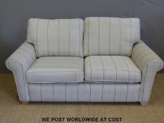 A modern two seater sofa bed with scatter cushions