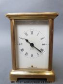 A late 20th century French brass carriage clock with Roman numerals to enamelled dial,