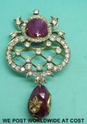 A yellow metal brooch set with round cut diamonds and a star ruby cabochon over a briolette ruby of